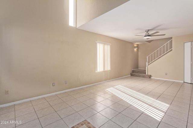 spare room with ceiling fan and light tile patterned flooring