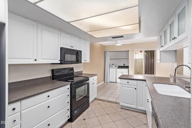 kitchen featuring black appliances, sink, ceiling fan, washing machine and dryer, and white cabinetry