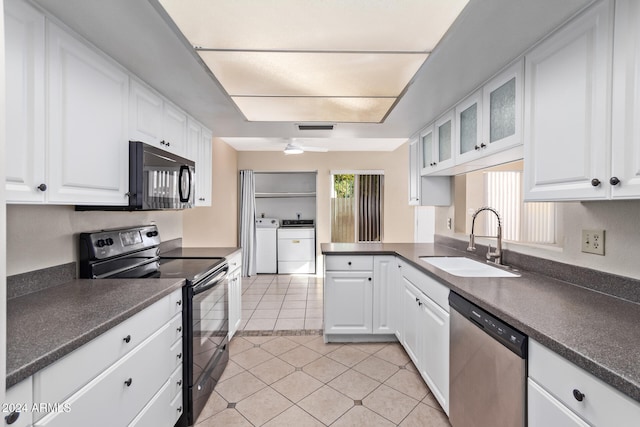 kitchen with washing machine and clothes dryer, white cabinetry, sink, and black appliances