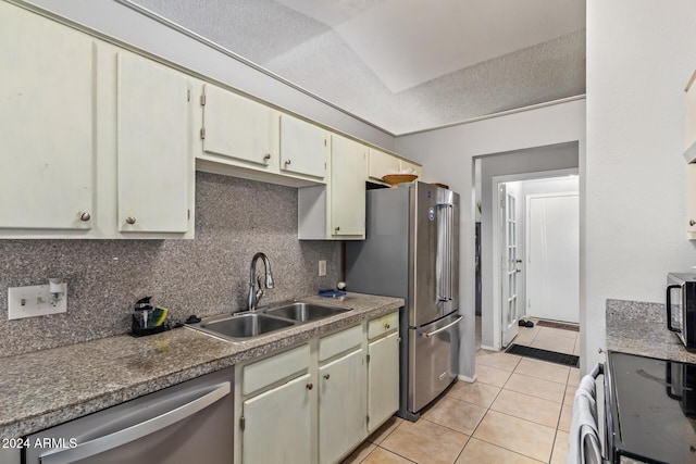 kitchen featuring appliances with stainless steel finishes, a textured ceiling, sink, light tile patterned floors, and cream cabinetry