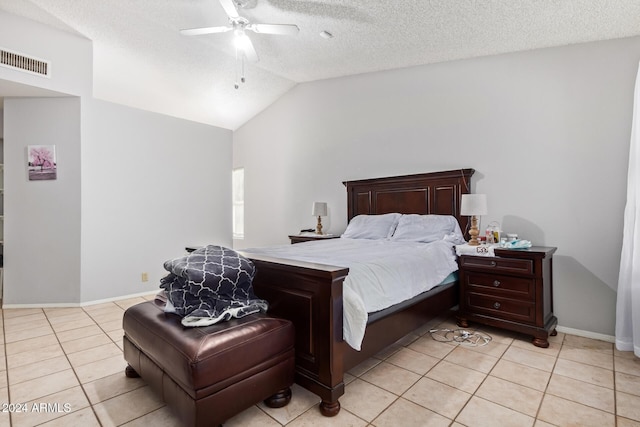 tiled bedroom featuring a textured ceiling, ceiling fan, and lofted ceiling