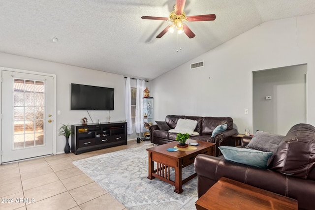 living room featuring a textured ceiling, ceiling fan, light tile patterned floors, and lofted ceiling