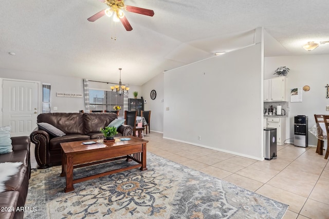 tiled living room with a textured ceiling, ceiling fan with notable chandelier, and vaulted ceiling