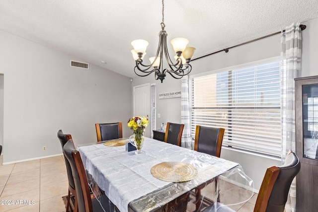 tiled dining area with a textured ceiling, vaulted ceiling, and a notable chandelier