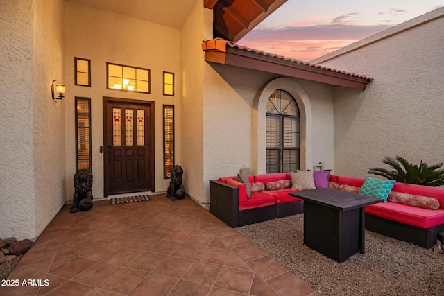 exterior entry at dusk featuring an outdoor hangout area and a patio area