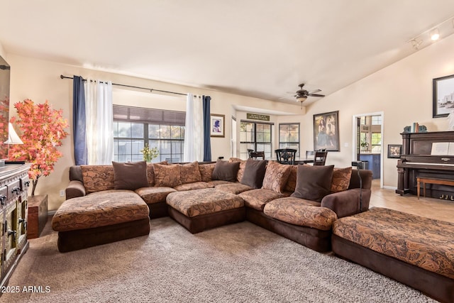 carpeted living room featuring ceiling fan and vaulted ceiling