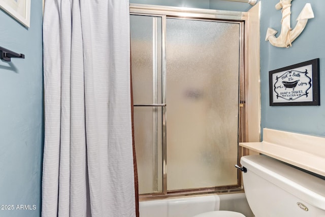 bathroom featuring toilet and combined bath / shower with glass door