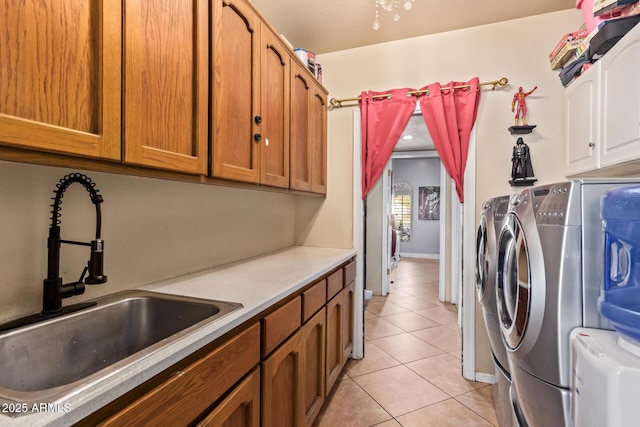 laundry area featuring cabinets, sink, light tile patterned floors, and independent washer and dryer