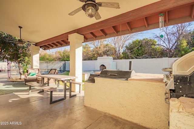 view of patio / terrace with ceiling fan, an outdoor kitchen, and an outdoor fireplace