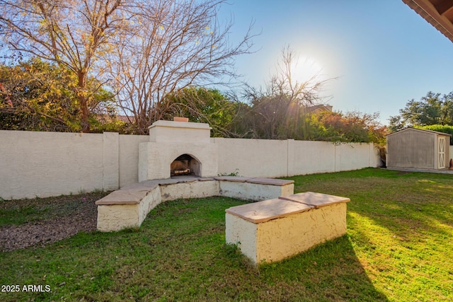 view of yard with exterior fireplace and a shed