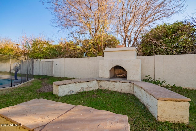 view of yard featuring exterior fireplace and a patio