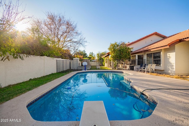 view of pool with a diving board and a patio