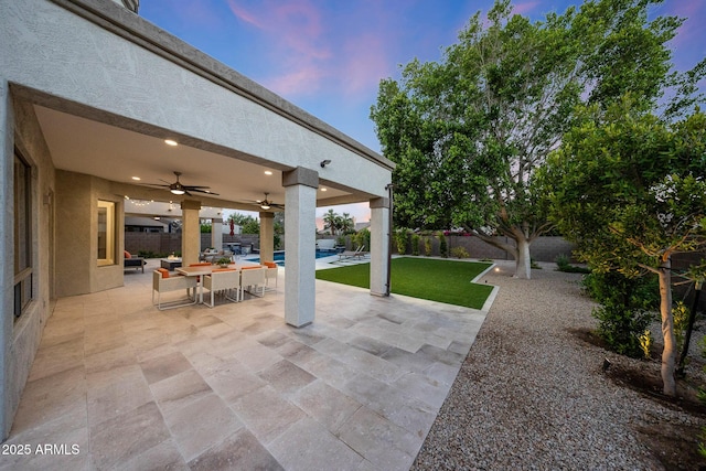 6435 E Monte Cristo Ave, Scottsdale, AZ 85254 - patio terrace at dusk featuring ceiling fan, a fenced backyard, a patio, and outdoor dining area