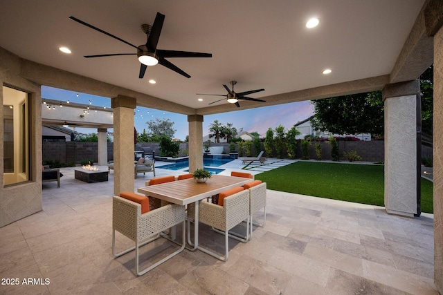 6435 E Monte Cristo Ave, Scottsdale, AZ 85254 - patio terrace at dusk with a patio, an outdoor fire pit, a fenced backyard, and outdoor dining space