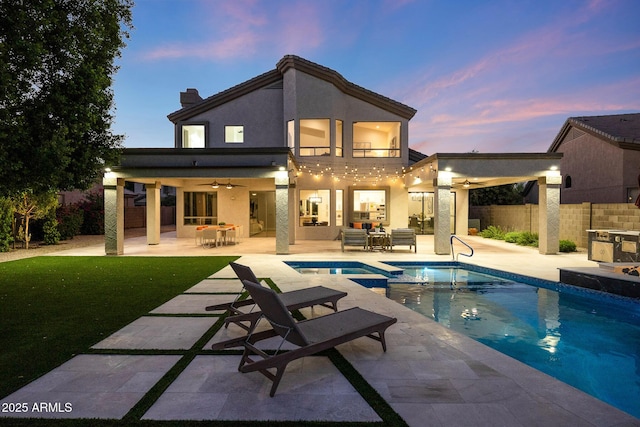 6435 E Monte Cristo Ave, Scottsdale, AZ 85254 - back of house at dusk featuring a ceiling fan, a patio, a balcony, and stucco siding