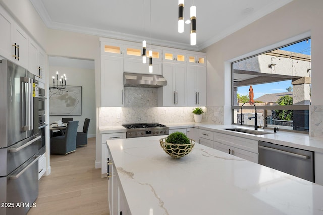 6435 E Monte Cristo Ave, Scottsdale, AZ 85254 - kitchen with stainless steel appliances, a chandelier, tasteful backsplash, light wood-style floors, and ornamental molding
