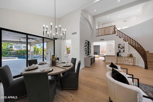 6435 E Monte Cristo Ave, Scottsdale, AZ 85254 - dining space with light wood-type flooring, a towering ceiling, a chandelier, and stairway