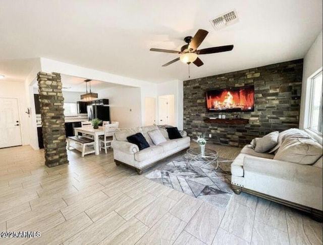 living room with ceiling fan and ornate columns