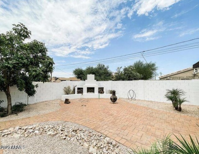 view of patio with an outdoor fireplace