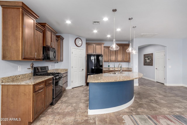 3937 N Smithsonian Dr, Florence, AZ 85132 - kitchen with light stone countertops, a sink, arched walkways, visible vents, and black appliances