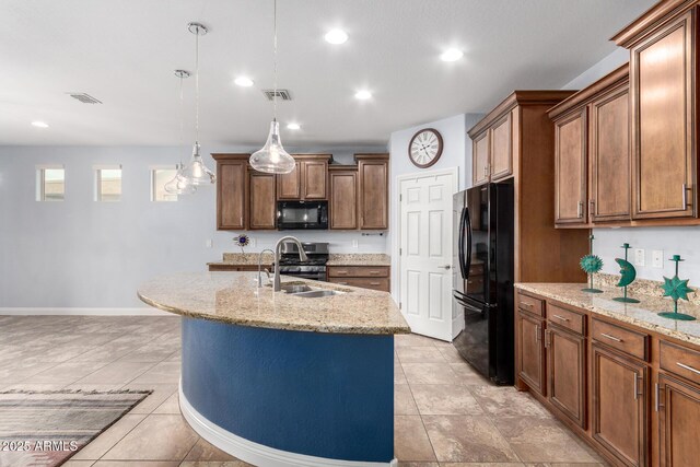 3937 N Smithsonian Dr, Florence, AZ 85132 - kitchen with a kitchen island with sink, visible vents, light stone countertops, baseboards, and black appliances