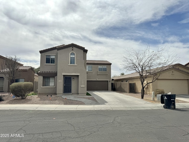 mediterranean / spanish home featuring driveway, stucco siding, a garage, and a tiled roof