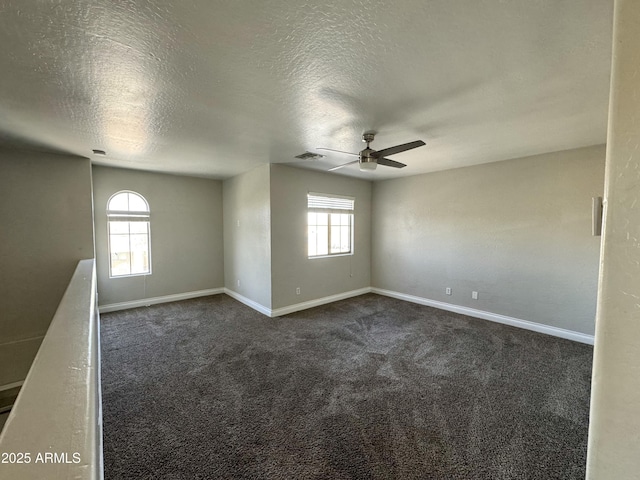 unfurnished room with dark colored carpet, visible vents, and baseboards