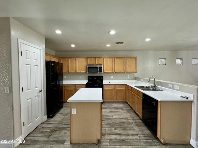 kitchen with black appliances, wood tiled floor, a sink, and a center island