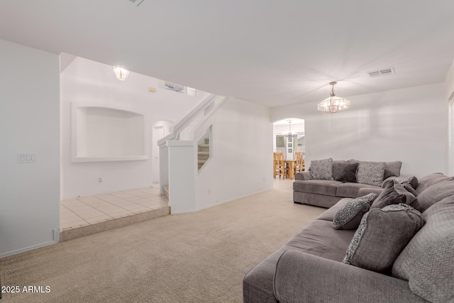 6276 N 75th Ln, Glendale, AZ 85303 - living area featuring arched walkways, a chandelier, carpet floors, stairway, and baseboards