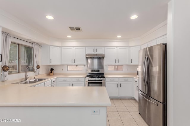 6276 N 75th Ln, Glendale, AZ 85303 - kitchen featuring appliances with stainless steel finishes, a sink, under cabinet range hood, a peninsula, and white cabinetry