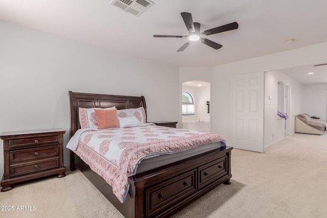 6276 N 75th Ln, Glendale, AZ 85303 - bedroom featuring arched walkways, light carpet, connected bathroom, a ceiling fan, and recessed lighting