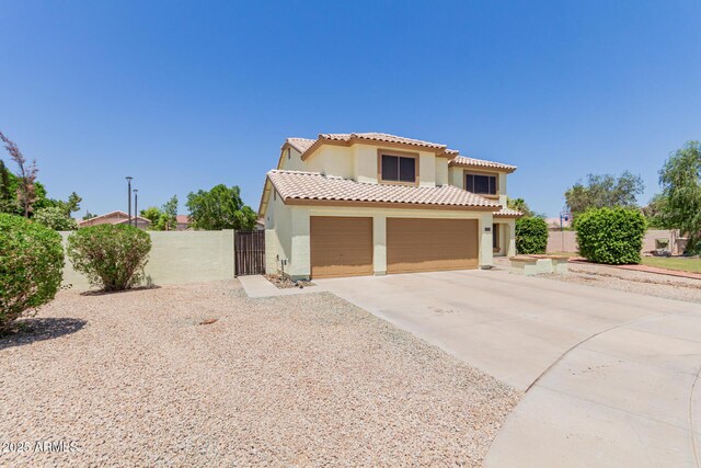 6276 N 75th Ln, Glendale, AZ 85303 - mediterranean / spanish home with stucco siding, a gate, concrete driveway, a tiled roof, and an attached garage