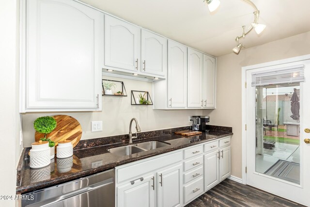 kitchen featuring dark stone counters, sink, and white cabinets