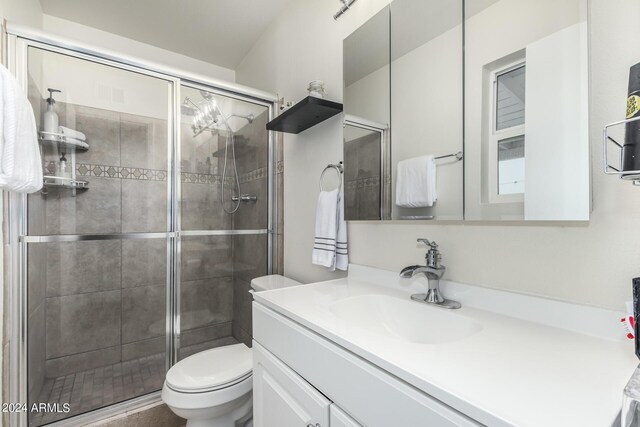 bathroom featuring vanity, toilet, and an enclosed shower