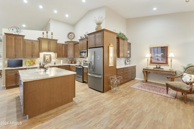 kitchen featuring backsplash, high vaulted ceiling, stainless steel appliances, and light wood-type flooring