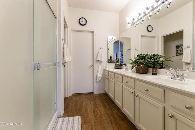 bathroom featuring vanity, an enclosed shower, and wood-type flooring