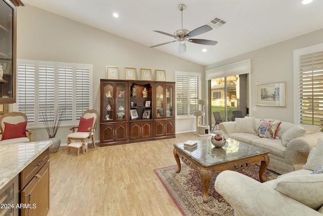 living room with light hardwood / wood-style floors, vaulted ceiling, and ceiling fan