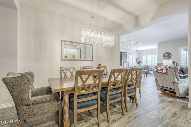 dining space with a notable chandelier and wood finished floors