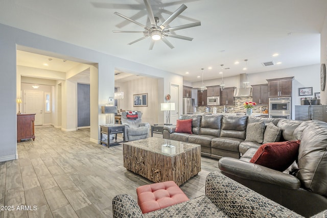 living area featuring visible vents, baseboards, ceiling fan, recessed lighting, and light wood-style flooring