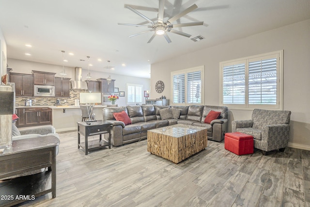 living room featuring light wood finished floors, visible vents, recessed lighting, and ceiling fan