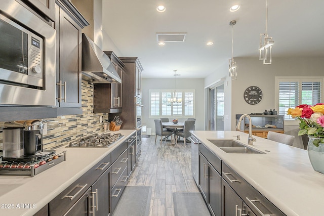 kitchen with light countertops, a wealth of natural light, decorative backsplash, appliances with stainless steel finishes, and a sink