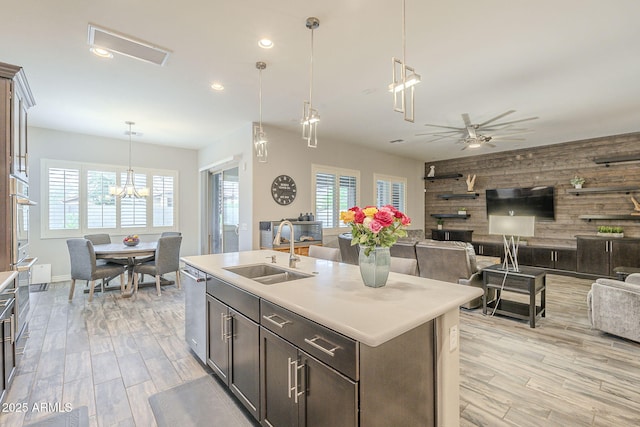 kitchen with a sink, open floor plan, appliances with stainless steel finishes, wood walls, and an accent wall