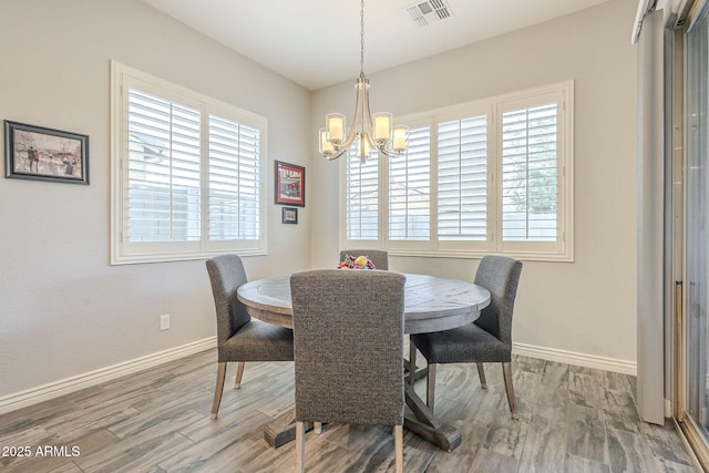 dining space with wood finished floors, visible vents, and a wealth of natural light