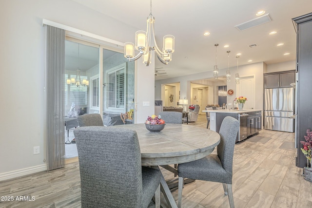 dining room with an inviting chandelier, recessed lighting, visible vents, and light wood finished floors