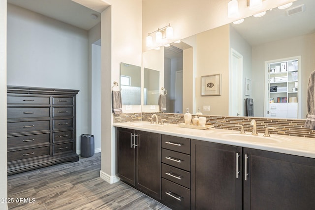 full bathroom featuring visible vents, wood finished floors, tasteful backsplash, and a sink