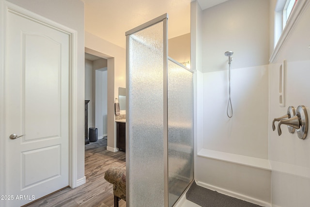 bathroom with a shower stall and wood finished floors