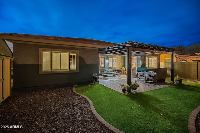 rear view of property with fence, stucco siding, a lawn, a pergola, and a patio