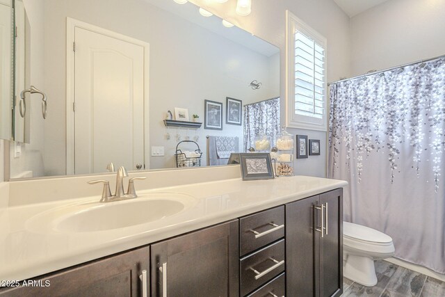 full bathroom featuring vanity, curtained shower, toilet, and wood finished floors