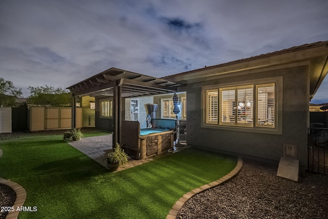 rear view of property with fence, stucco siding, a yard, a patio area, and a pergola