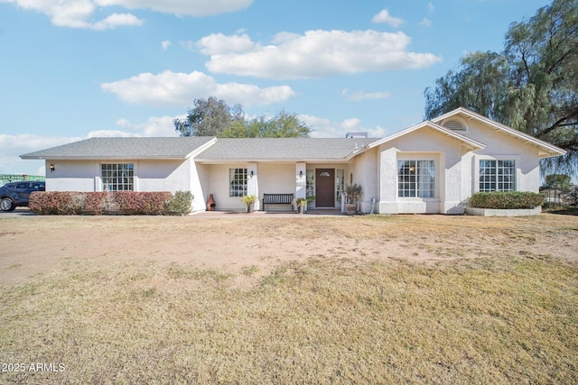 ranch-style house with covered porch and a front yard